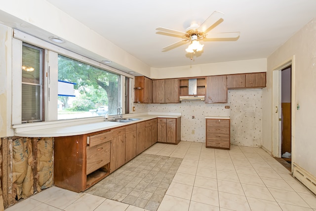 kitchen featuring a baseboard radiator, sink, ceiling fan, and light tile patterned floors