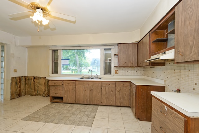 kitchen with decorative backsplash, light tile patterned floors, sink, and ceiling fan