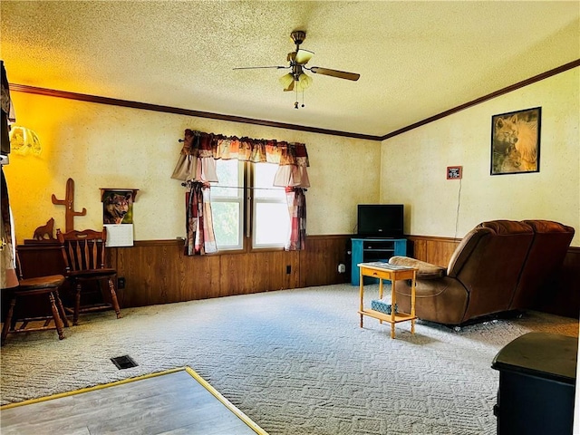 living room with ceiling fan, carpet floors, and a textured ceiling