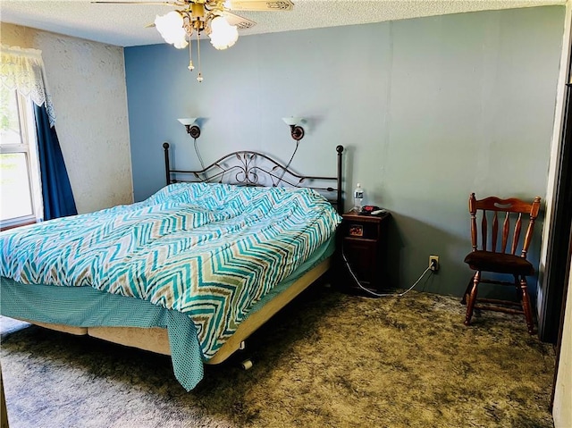 carpeted bedroom featuring ceiling fan and a textured ceiling