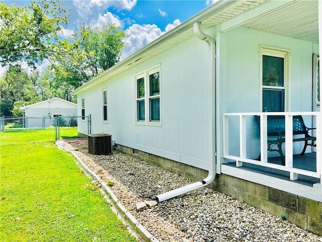 view of side of home with a yard and central air condition unit