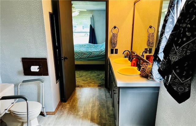 bathroom featuring wood-type flooring, vanity, and toilet