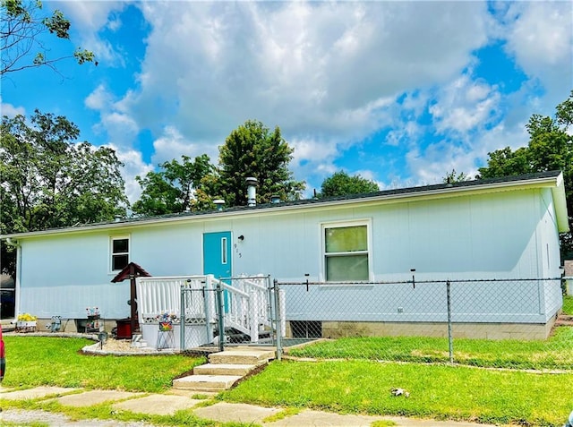 rear view of property featuring a lawn