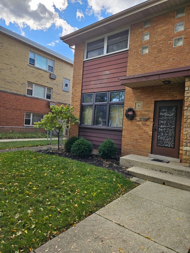 view of exterior entry featuring a lawn