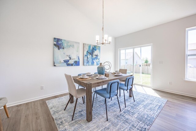 dining area with light hardwood / wood-style floors, a wealth of natural light, and high vaulted ceiling