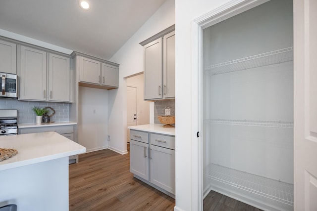 kitchen featuring appliances with stainless steel finishes, light countertops, dark wood finished floors, and gray cabinetry