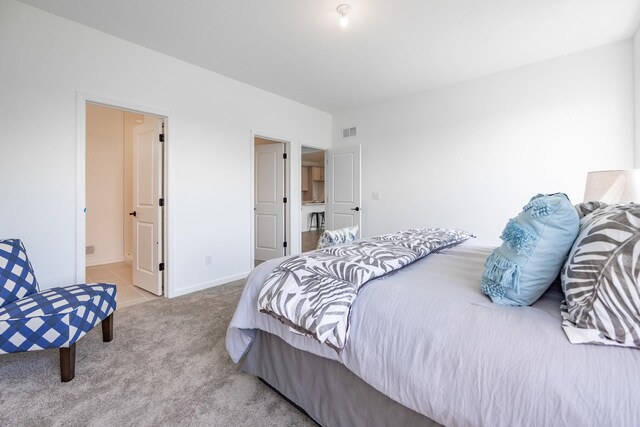 carpeted bedroom featuring ensuite bathroom