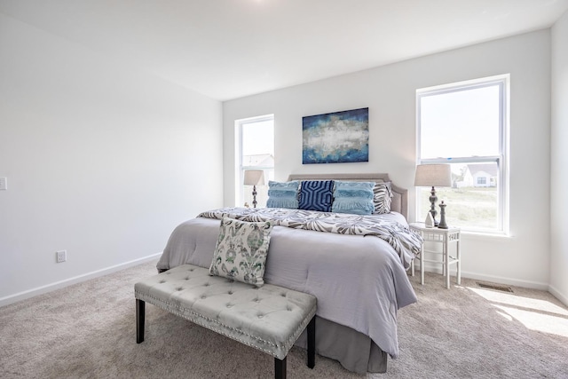 bedroom with light colored carpet, visible vents, and baseboards