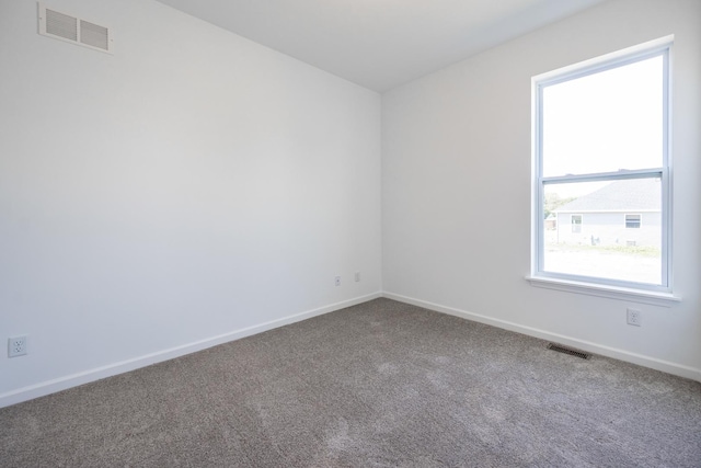 empty room featuring carpet, visible vents, and baseboards