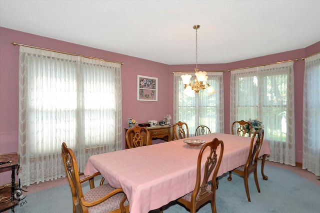 dining room with plenty of natural light, a chandelier, and light colored carpet