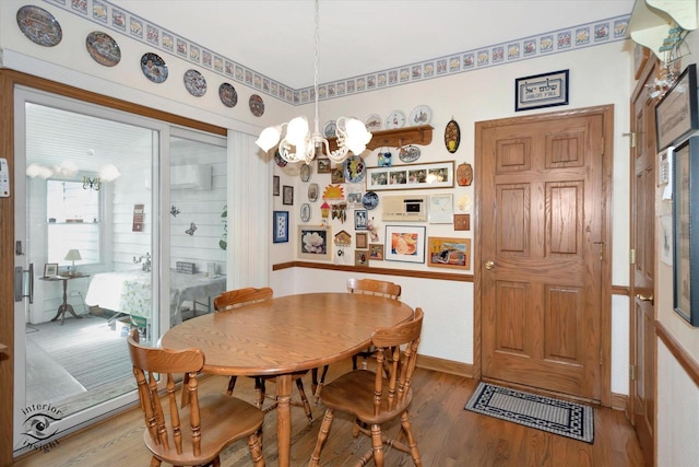 dining room with baseboards, wood finished floors, and an inviting chandelier