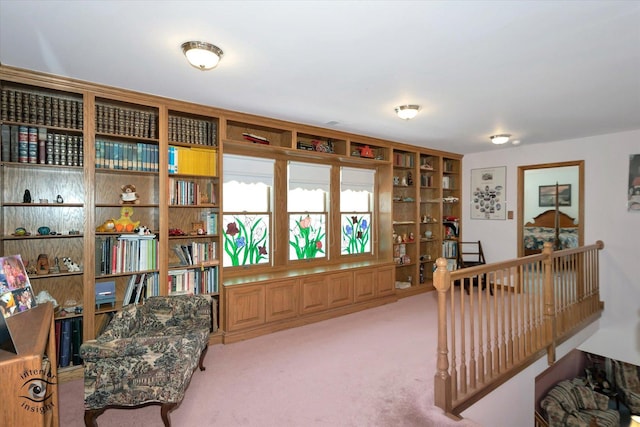 living area featuring light carpet and an upstairs landing