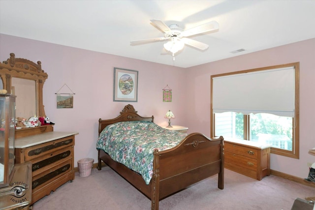 bedroom featuring baseboards, visible vents, a ceiling fan, and light colored carpet