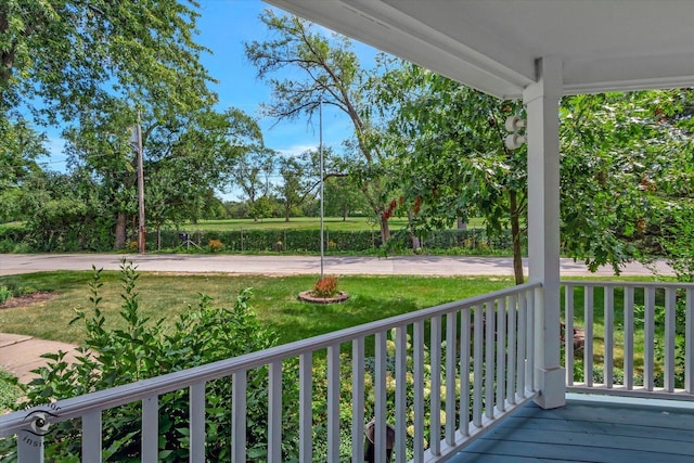 deck featuring covered porch and a yard