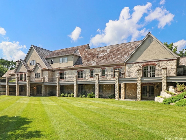 rear view of property featuring a lawn