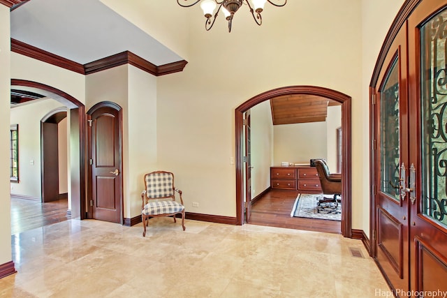 entrance foyer featuring ornamental molding and a chandelier