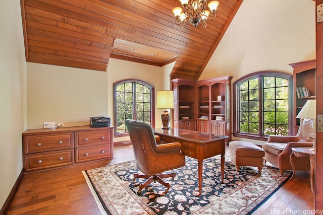 home office featuring a notable chandelier, a towering ceiling, hardwood / wood-style floors, and wooden ceiling