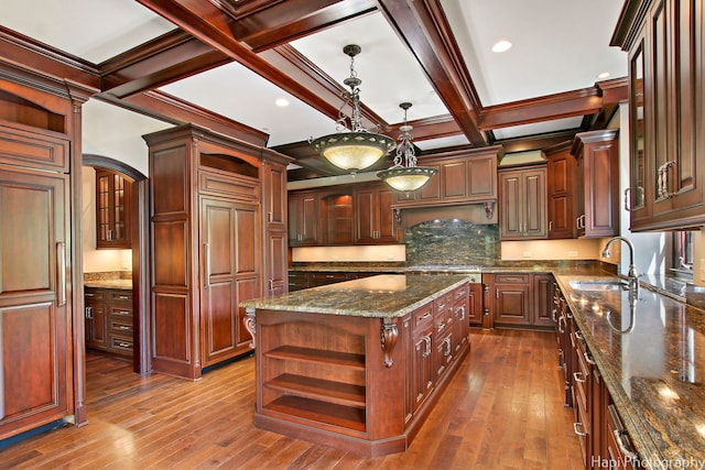 kitchen featuring sink, dark hardwood / wood-style floors, coffered ceiling, a kitchen island, and beamed ceiling