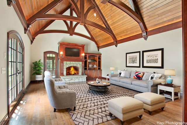 living room with wood ceiling, light hardwood / wood-style flooring, beam ceiling, high vaulted ceiling, and a fireplace