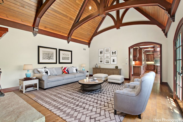 living room with beam ceiling, high vaulted ceiling, hardwood / wood-style floors, and wood ceiling