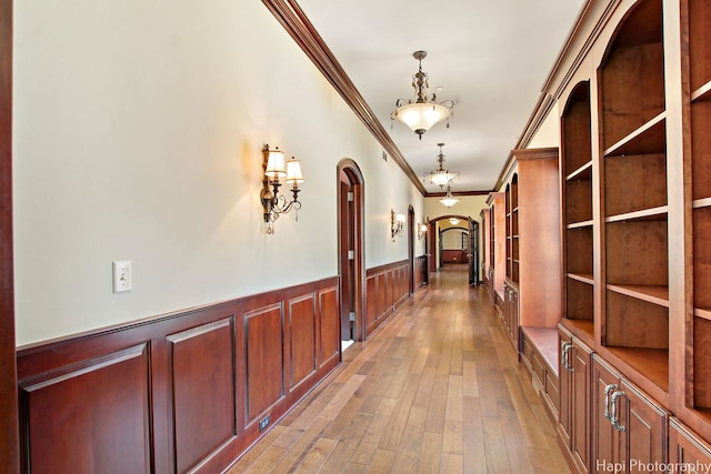 hall with crown molding and light wood-type flooring