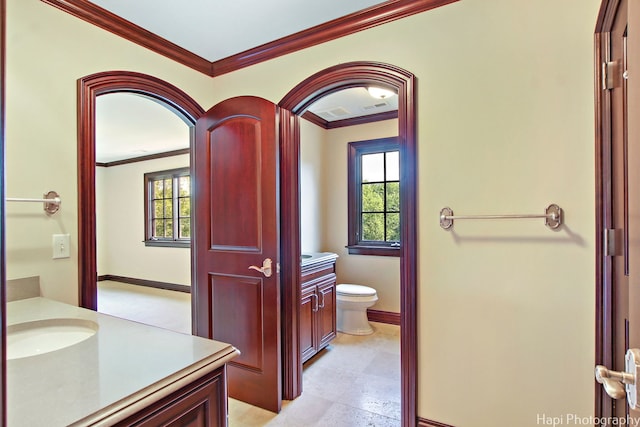 bathroom featuring ornamental molding, toilet, and vanity