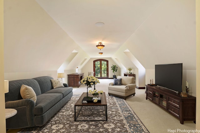 carpeted living room with lofted ceiling with skylight