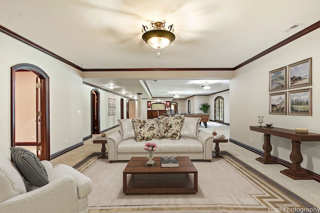 living room with ornamental molding and light colored carpet