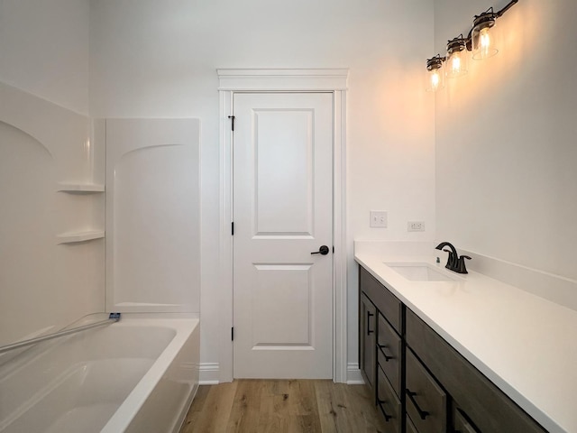 bathroom with vanity, a tub, and hardwood / wood-style floors