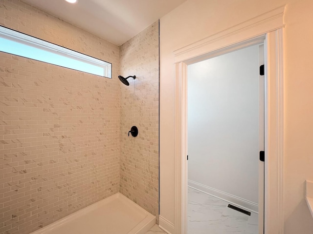 bathroom featuring a tile shower