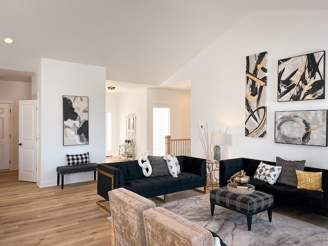 living room featuring light wood-type flooring and vaulted ceiling