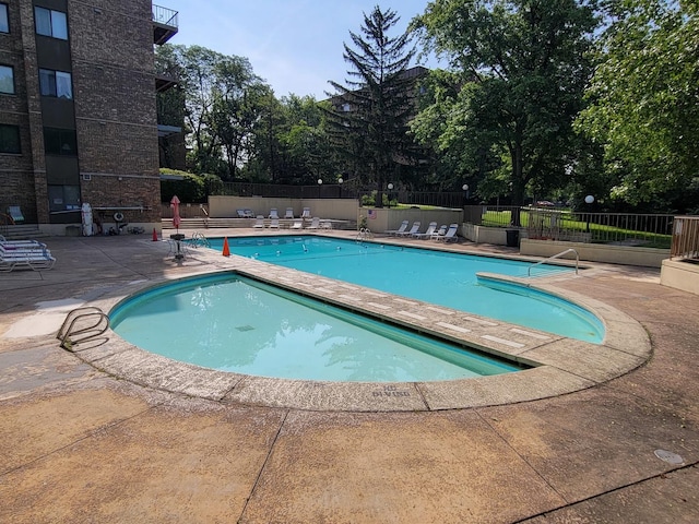 pool featuring a patio area and fence