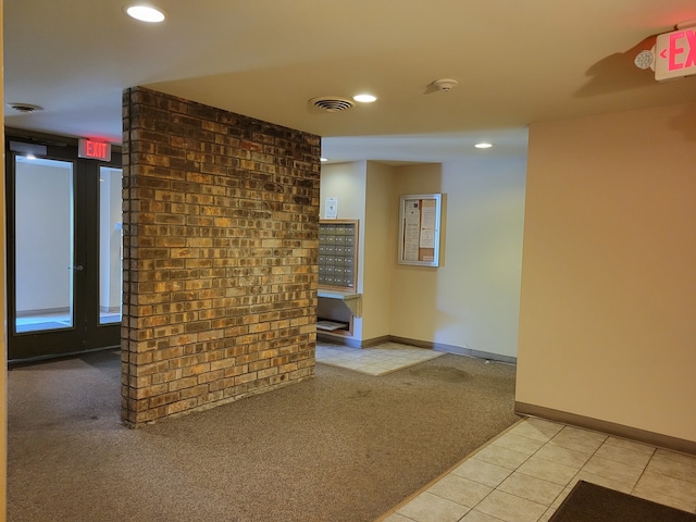 interior space featuring brick wall and light colored carpet