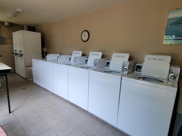 shared laundry area featuring stacked washer and clothes dryer, light tile patterned flooring, and independent washer and dryer