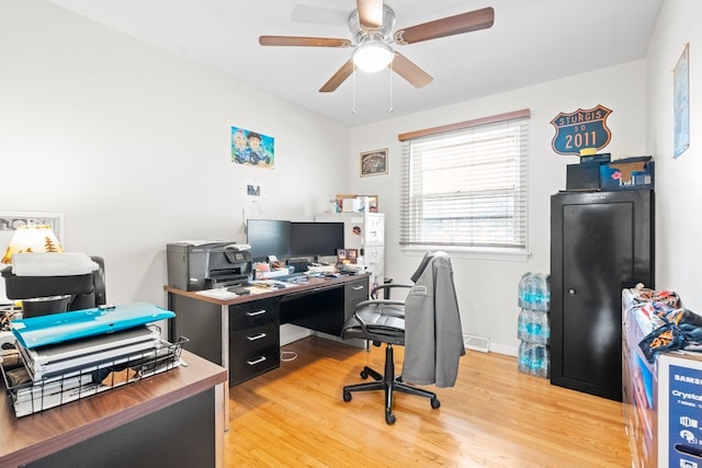 home office with light hardwood / wood-style flooring and ceiling fan