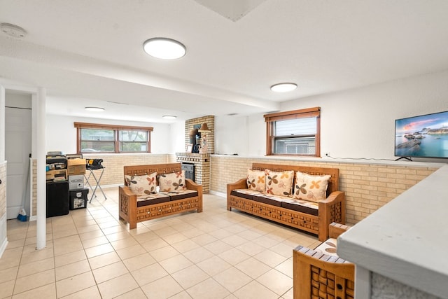 tiled living room featuring brick wall