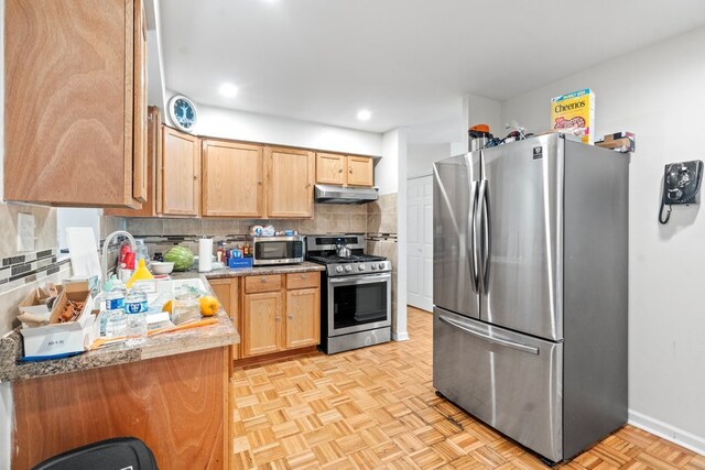 kitchen with light parquet floors, light brown cabinets, tasteful backsplash, and stainless steel appliances