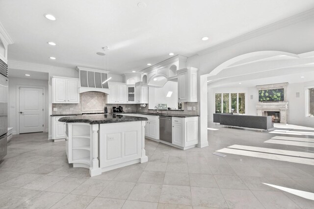 kitchen with premium range hood, white cabinetry, open floor plan, a lit fireplace, and a center island