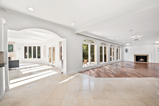 unfurnished living room with baseboards, a lit fireplace, ornamental molding, and recessed lighting