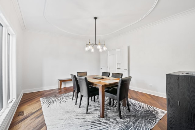 dining room featuring baseboards, visible vents, ornamental molding, and wood finished floors