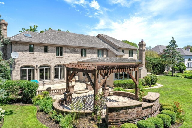 back of property with a patio, brick siding, a yard, a pergola, and a chimney