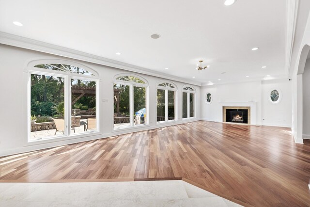 unfurnished living room with a fireplace with flush hearth, ornamental molding, wood finished floors, and recessed lighting