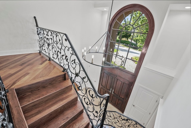 foyer entrance with a chandelier, light wood finished floors, and baseboards