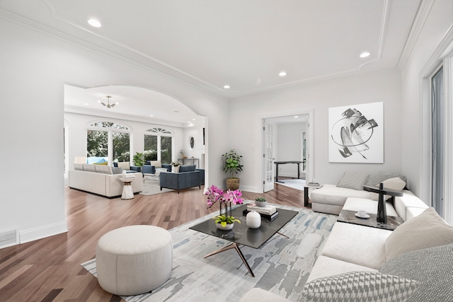 living room with ornamental molding, recessed lighting, baseboards, and wood finished floors