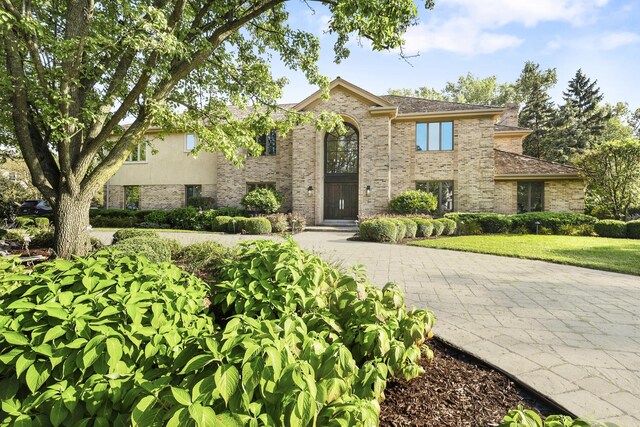 view of front of house featuring brick siding and a front lawn