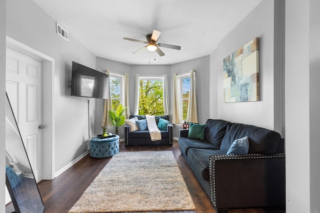 living room featuring ceiling fan and dark hardwood / wood-style floors