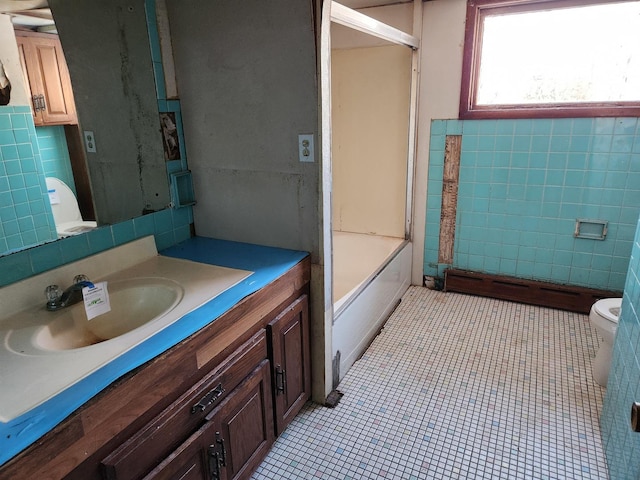 full bathroom with vanity, toilet, tile patterned flooring, and tile walls