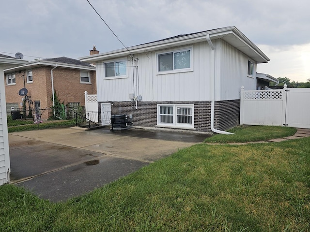 back of house with a yard, cooling unit, and a patio area