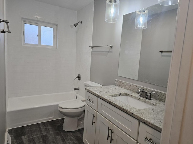 full bathroom featuring tiled shower / bath combo, vanity, hardwood / wood-style floors, and toilet