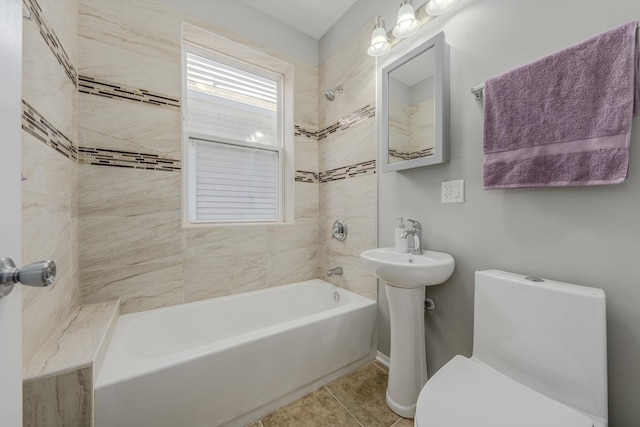 bathroom featuring tiled shower / bath combo, tile patterned floors, and toilet